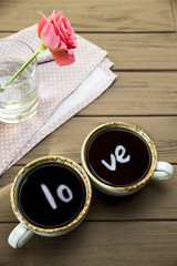 The word love is reflected in two cups of coffee. Valentine's Day Concept