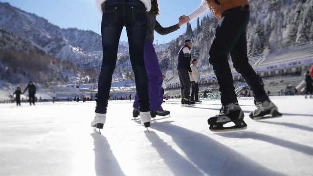 Funny teenagers girls and boy skating outdoor, ice rink