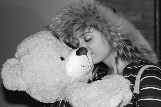 smiling girl embracing bear shaped pelouche