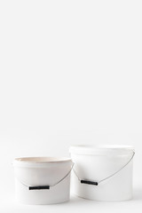 two plastic white buckets with paints isolated on white