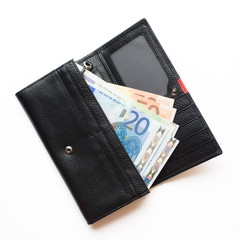 Woman black purse (wallet) with euro banknotes isolated on white background