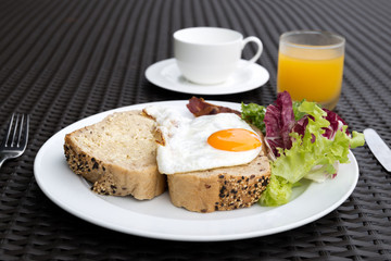 Breakfast set with fried eggs,vegetable,bread,coffee and orange juice