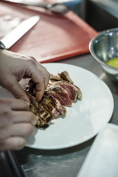 Chef serving meat in a plate
