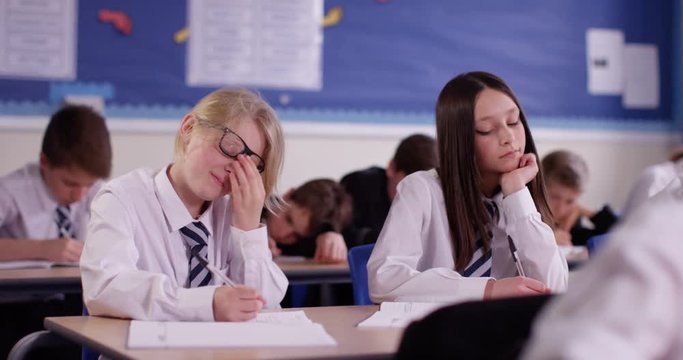 4k, Candid shot of two girls in a class studying alongside their classmates.
