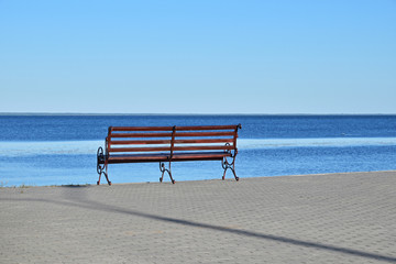 Seat bench on paved bank of river