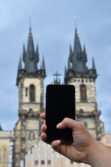 Man hand taking picture of Prague with phone