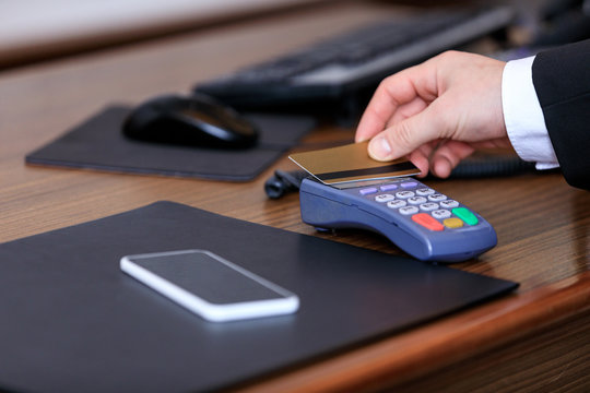 cropped image of businessman paying with credit card in hotel