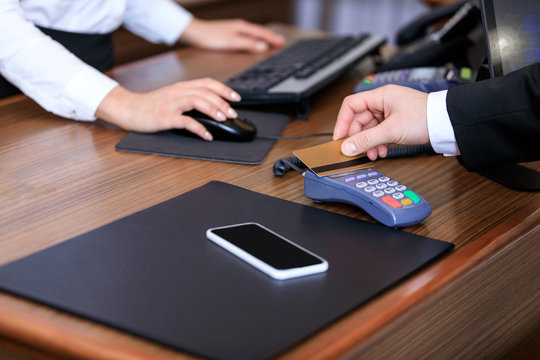 cropped image of businessman paying with credit card at reception desk in hotel