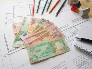 Arab dirhams and euros against the background of an architectural project.
