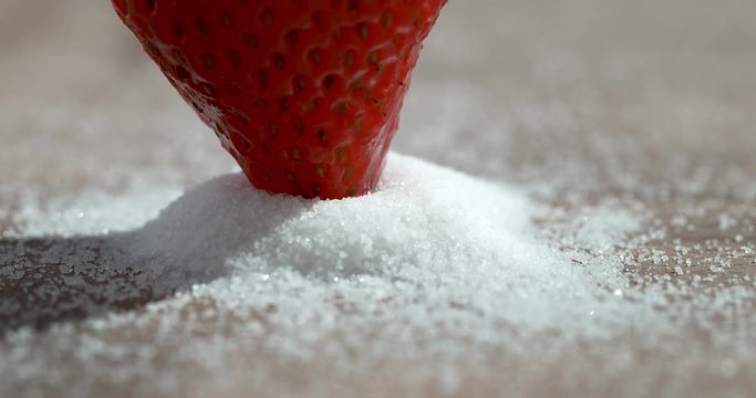 Strawberry in white sugar shot in super slow motion