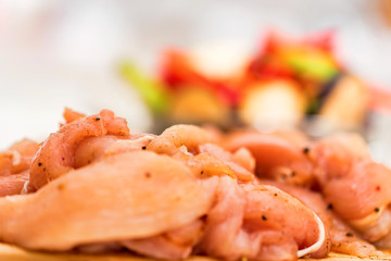 Raw spiced chicken fillet and fresh vegetables