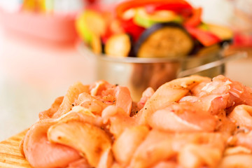 Raw spiced chicken fillet and fresh vegetables