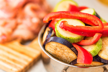 Fresh sliced vegetables in metal pan and meat