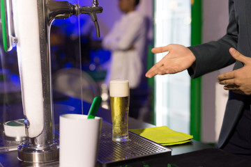 Waiter with glass of  beer in pub