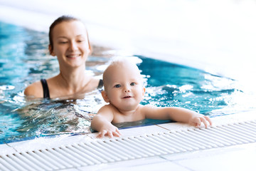 Smiling charming baby in swimming pool