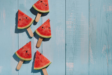 Slices of watermelon on blue wooden desk.