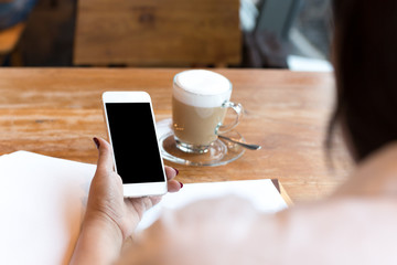 businesswoman using cell phone with cup of coffee while working in finances