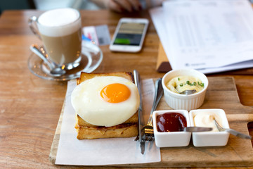 Toast cheese sandwiches with fried egg and coffee with businesswoman working