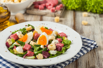Delicious Italian salad with salami, egg, crostini and mozzarella.
