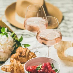 Foto op Canvas Romantische zomerpicknick in Franse stijl. Plat leggen van glazen rose wijn met ijs, verse aardbeien, croissants, brie, strohoed, pioenrozen, vierkant gewas. Concept voor buiten verzamelen © sonyakamoz