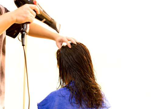 Man hairdresser using blower to dry customer hair