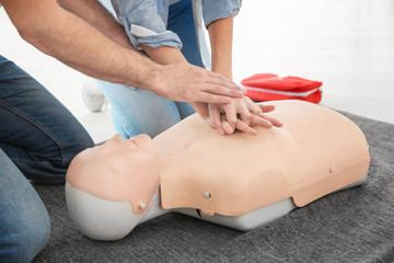 Woman practicing CPR on mannequin in first aid class, closeup