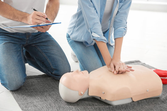 Woman practicing CPR on mannequin in first aid class, closeup