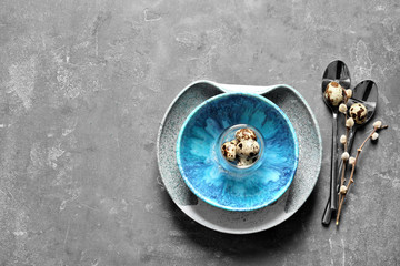 Beautiful festive Easter table setting with quail eggs on gray background