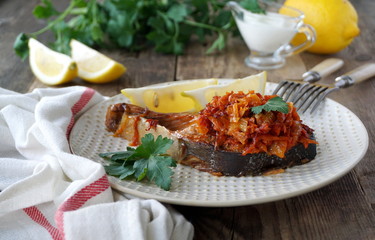Baked red fish steak with carrots and onions