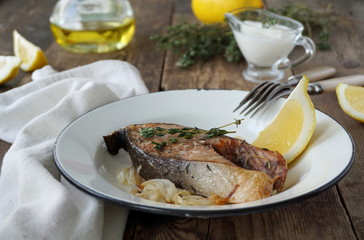 Steak of red fish with onions, thyme and lemon