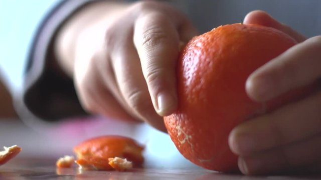 child purifies peel of mandarin, time lapse
