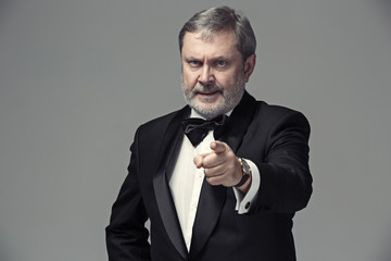 Senior Businessman standing and pointing to camera