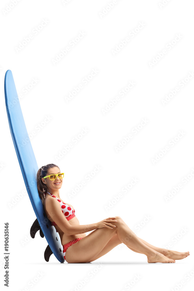 Sticker young woman seated on the floor leaning against a surfboard