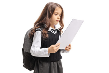 Sad little schoolgirl looking at an exam