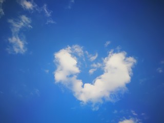 Fluffy heart shape clouds in blue sky for Valentine's background
