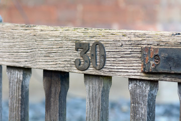 House number 30 sign fixed to wooden gate