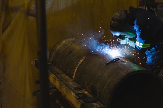 Welder repairing vessel part