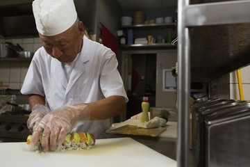 Senior chef preparing sushi in kitchen