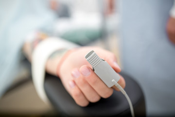pulse oximeter on finger of patient during surgery. male patient lying on the hospital bed....