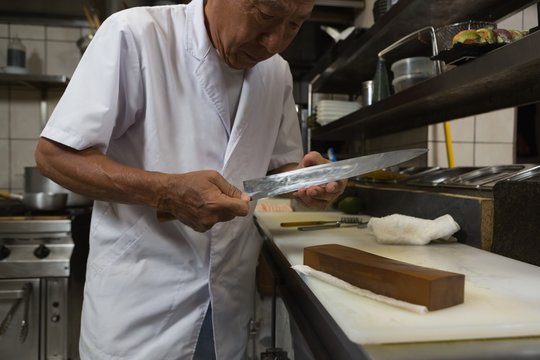 Senior chef holding knife in kitchen