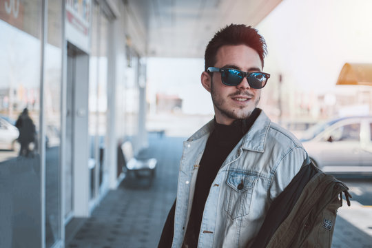 Young attractive male model looking in distance and smiling. Fashion, texas, sunglasses wearing.