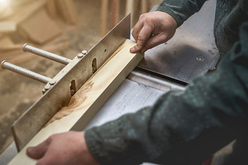 the man processes bar from a light tree on the jointer plane