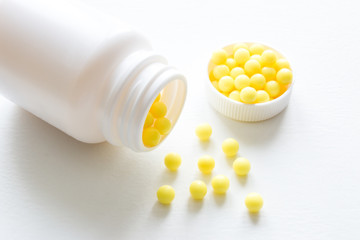 white bottle and pills of vitamin c on the white background