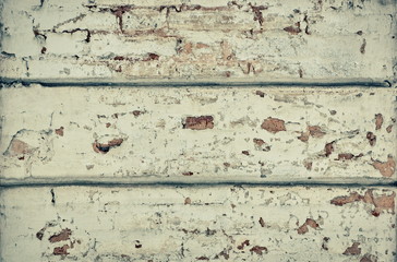 white wall of old plaster cracks are visible bricks grunge