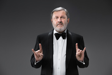 Middle aged male adult wearing a suit isolated on gray