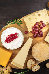 Various types of cheese on rustic background with copyspace