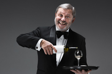 professional waiter in uniform is serving wine