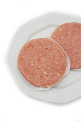 Raw fresh chicken burgers on a plate isolated on white background
