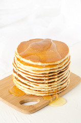 stack of pancakes on a yellow plate with honey