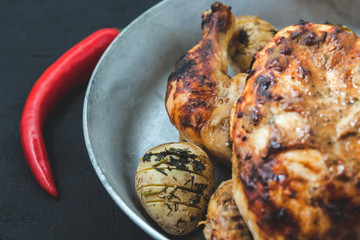 fried chicken with baked potatoes in a frying pan. Menu, restaurant and recipe concept
